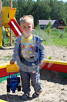 Ñ Ñ€ÑƒÑÑ little baby boy five years old playing on the Playground in the sandbox with toys in the summer